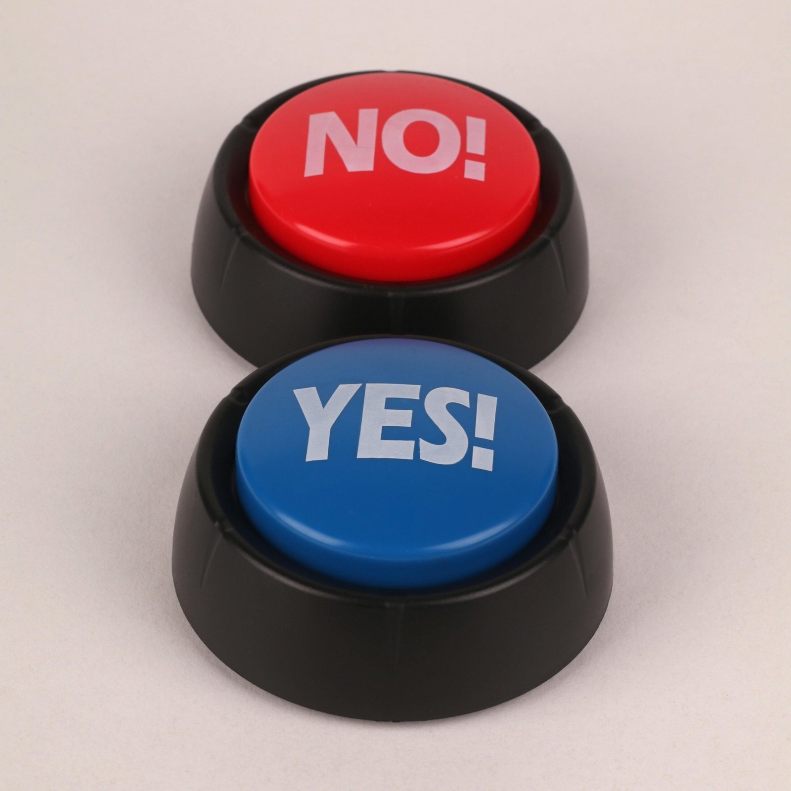 Close-up of red and blue buttons labeled 'Yes' and 'No' on beige background.